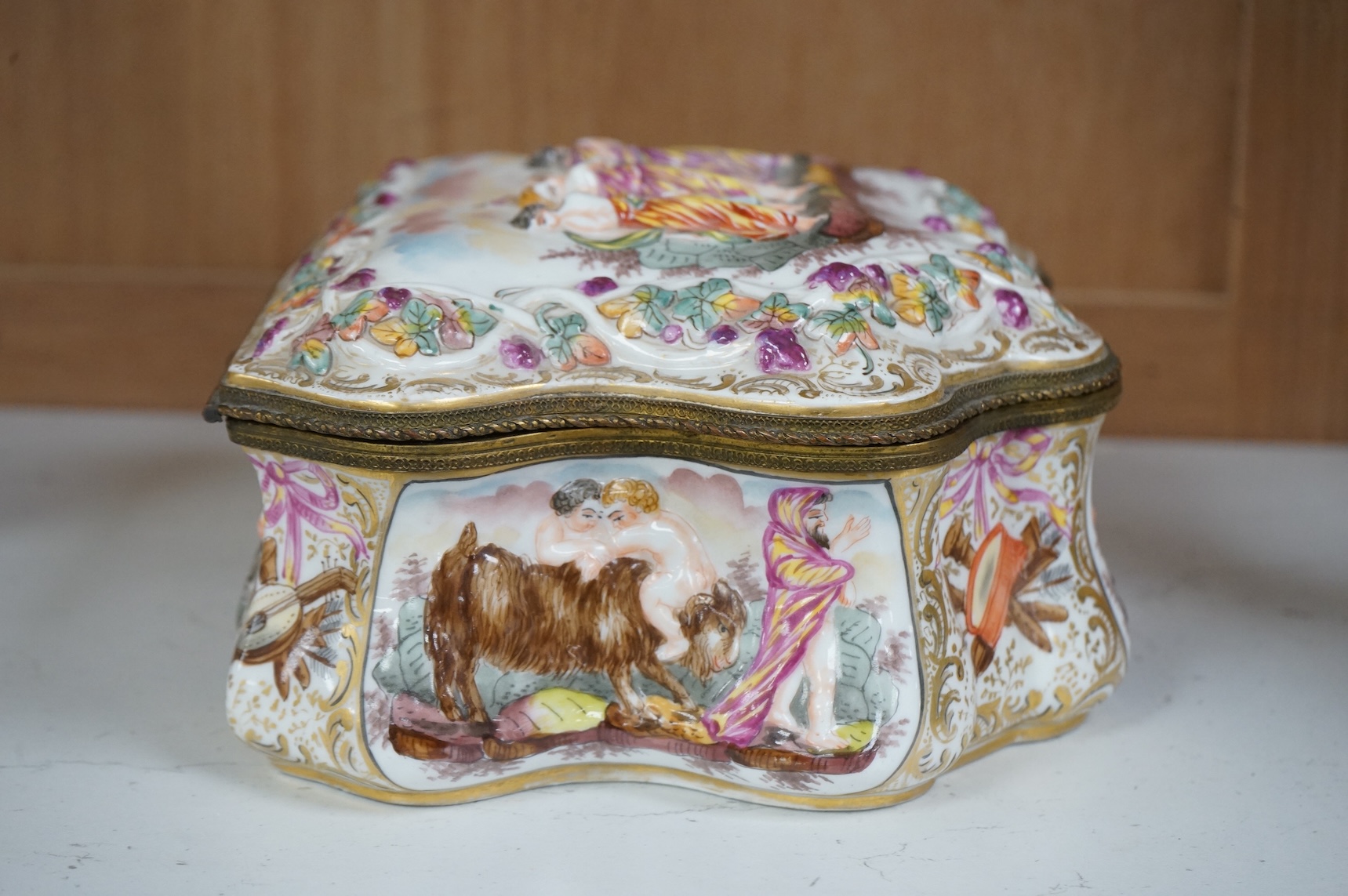 An ornate Neapolitan Capodimonte porcelain box with gilt mounts, 22cm wide, 11cm high